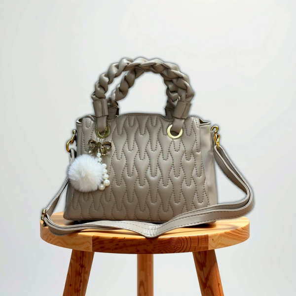 Elegant Quilted Handbag with Braided Handles and Charm Accent